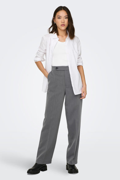 Grijze broek van ONLY, met een knoop, gecombineerd met een wit hemd en zwarte schoenen met dikke zolen.