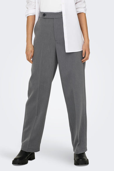 Grijze broek van ONLY, met hoge taille en rechte pijpen, gecombineerd met een wit overhemd en zwarte laarzen.
