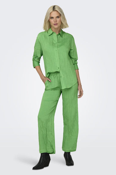 Groene broek van ONLY met een gekreukte textuur, gecombineerd met een bijpassend groen overhemd en zwarte laarsjes.