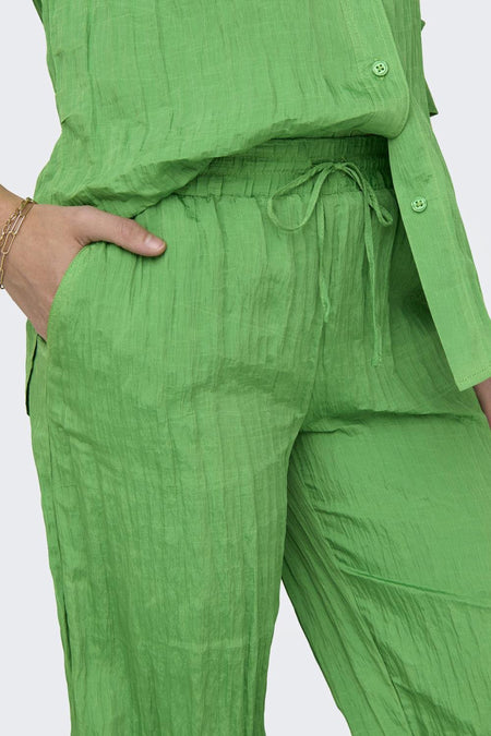 Groene broek van ONLY, met trekkoord in de taille en een hand in de zak.