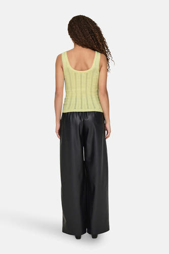 Gele top van JDY met een ribgebreide textuur, gedragen met zwarte, lange broek.
