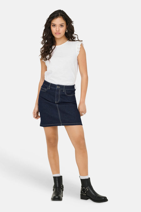 T-shirt blanc de JDY, avec détails de manches festonnés en dentelle, porté avec une jupe en jean foncé et des bottes noires.