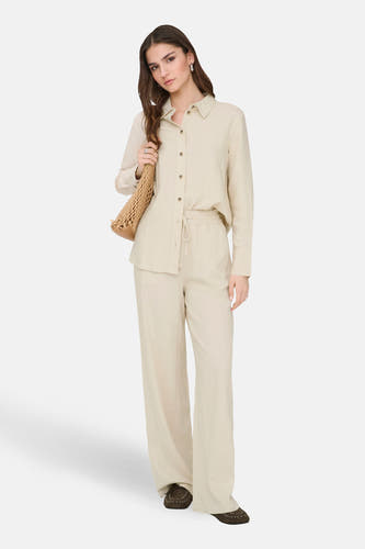 Pantalon beige de JDY, à jambes larges, combiné avec un chemisier beige et un sac à bandoulière en crochet.