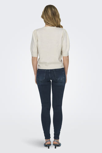 T-shirt blanc ONLY, avec des manches courtes, associé à un jean foncé et des baskets bleues, vu de dos.