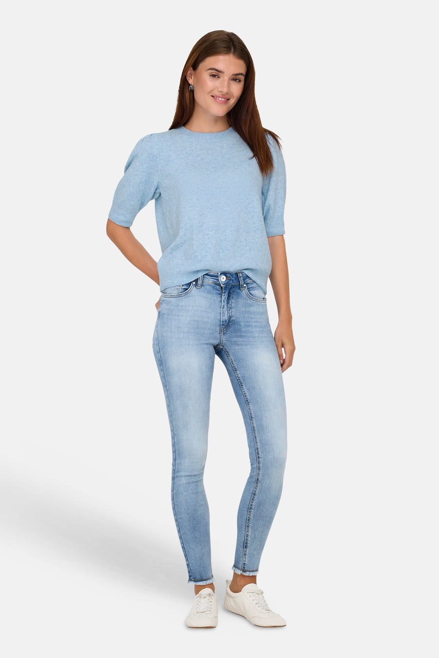 Lichtblauwe trui met ronde hals van ONLY, met korte mouwen en gecombineerd met een lichte jeans en witte sneakers.
