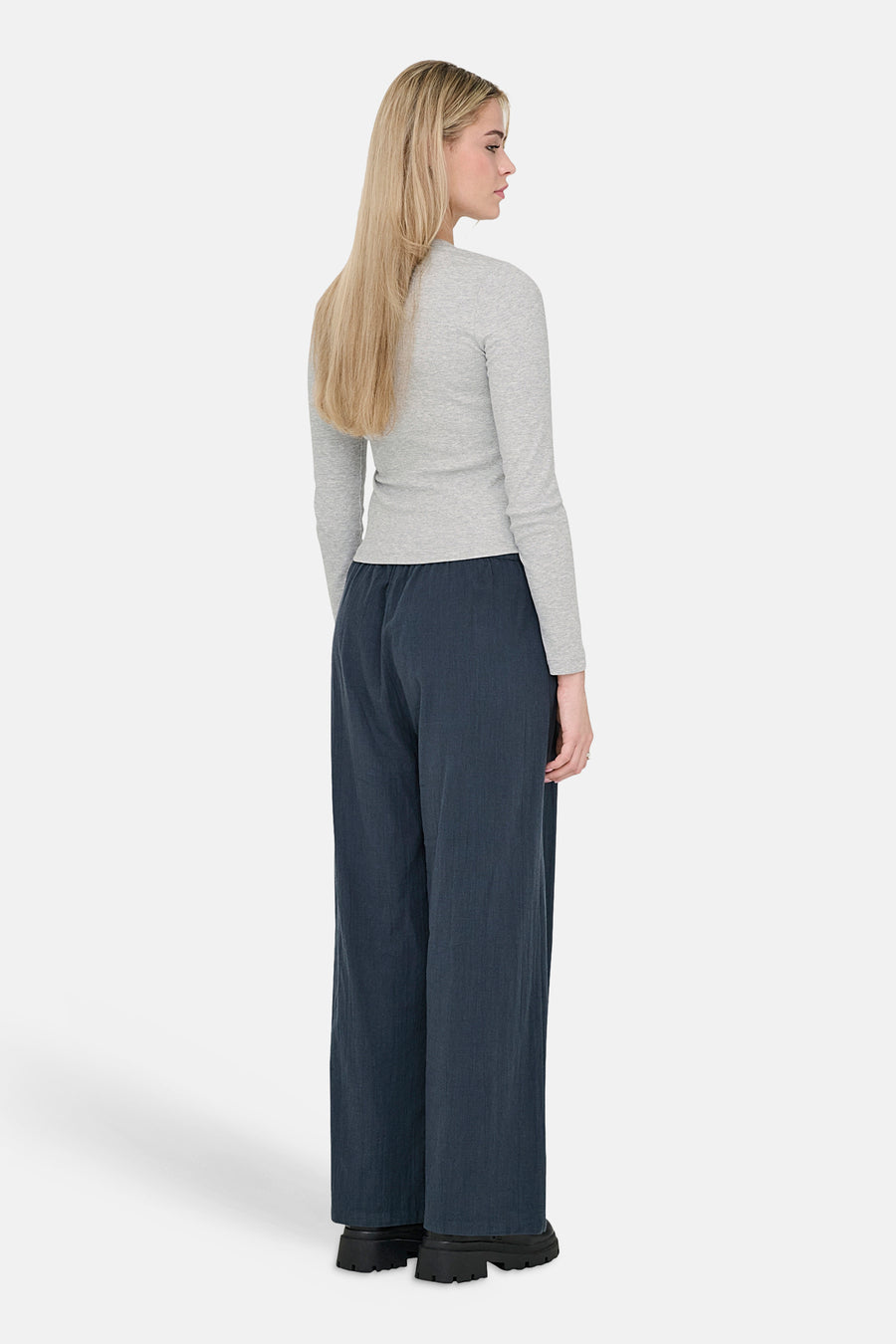 Pantalon bleu d'ONLY, à jambes larges, porté avec un t-shirt gris à manches longues.