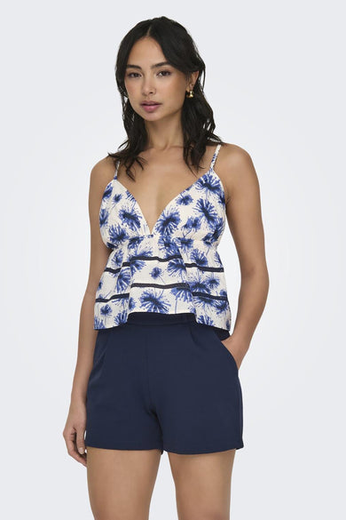 Witte mouwloze blouse met blauwe bloemenprint en ruches van ONLY®, gedragen met donkerblauwe korte broek, front view