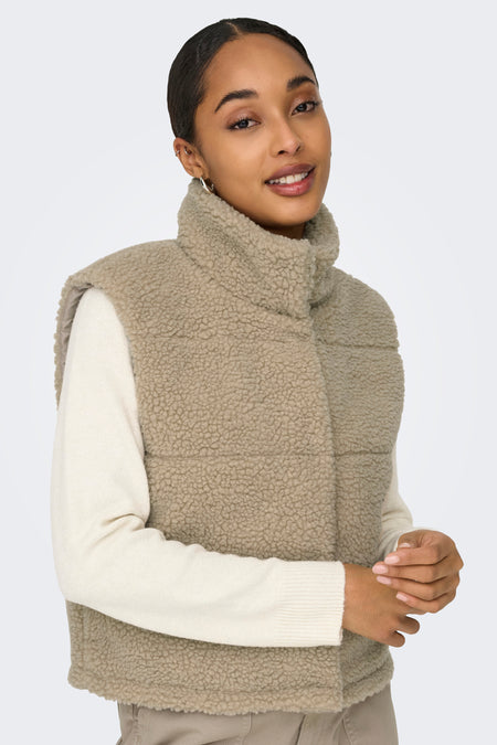 Doudoune sans manches beige imitation fourrure de ONLY® avec col montant, portée sur un pull crème, vue de face