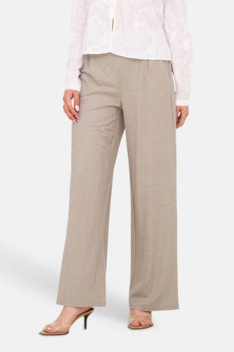 Beige broek van JDY met wijde pijpen, gedragen met een witte geborduurde blouse en hakken.