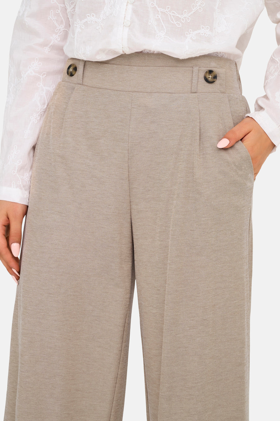Beige broek van JDY met knopen, plooien en steekzakken, gedragen met een witte geborduurde blouse.