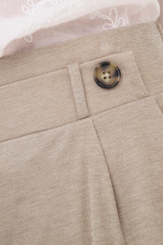 Beige broek van JDY met een bruine knoop, fijne textuur en witte kanten top erboven.