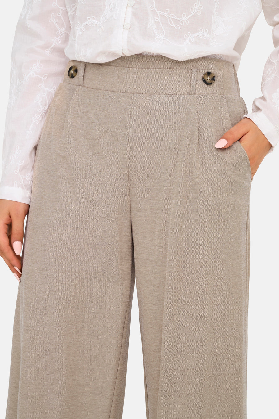 Beige broek van JDY met hoge tailleband met knopen en een hand in de zak.
