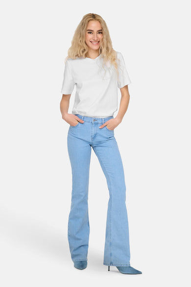 Wit T-shirt met korte mouwen van ONLY, gedragen met blauwe spijkerbroek en hakken.
