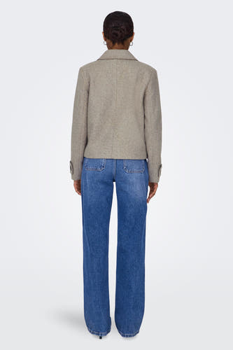 Beige korte jas van ONLY, gezien van achteren, gecombineerd met een blauwe jeans.