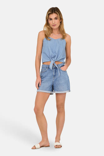 Lichtblauwe denim short van ONLY, met omslag en steekzakken, gecombineerd met een top in dezelfde kleur en sandalen.

