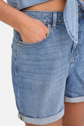 Short en denim bleu clair de ONLY, avec un ourlet replié et une main dans la poche.