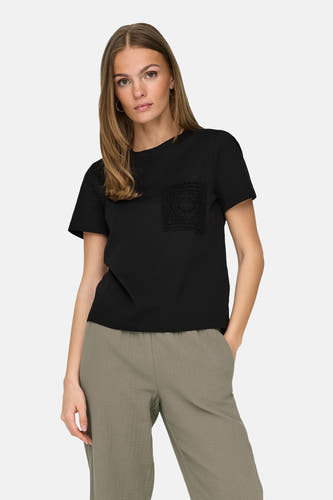 T-shirt noir à manches courtes de JDY, avec un sac tricoté et associé à un pantalon vert.