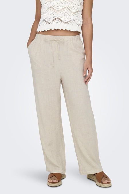 Jean écru de ONLY, avec cordon et poches, associé à un pull tricoté et des sandales espadrilles.