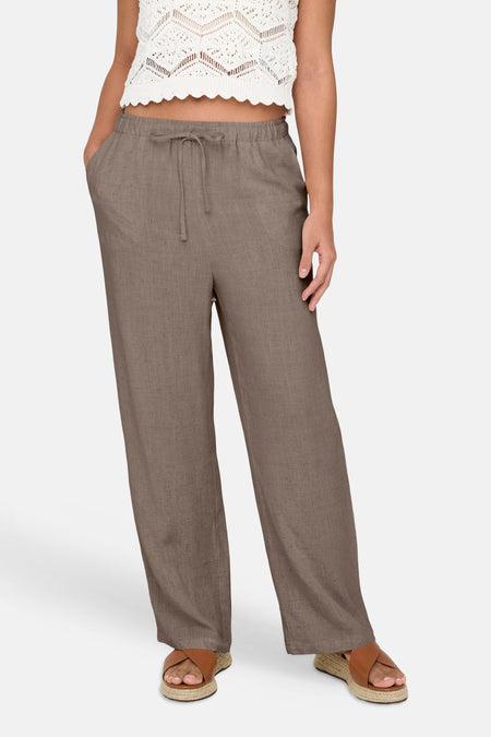 Bruine linnen broek van ONLY® met elastische taille en trekkoord, breed model, vooraanzicht, gedragen met witte gebreide top en espadrilles
