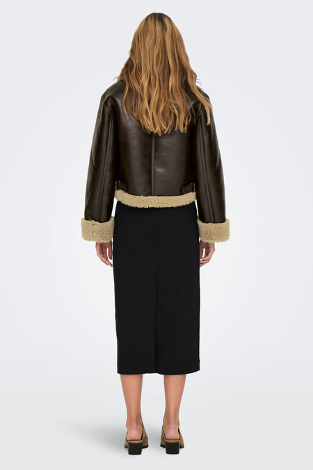 Manteau court brun d'ONLY, avec collet et porté sur une jupe noire en cuir et des chaussures.