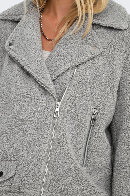 Manteau gris ONLY, avec une texture teddy grossière et des fermetures à glissière argentées.