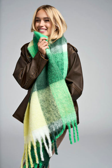 Manteau d'hiver vert ONLY avec un motif à carreaux et des franges, porté avec une veste en cuir marron.