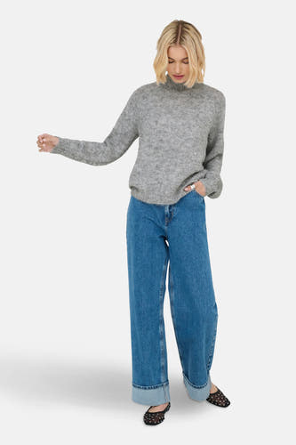 Manteau gris de JDY, porté avec des jeans larges à revers et des ballerines noires transparentes à pois.