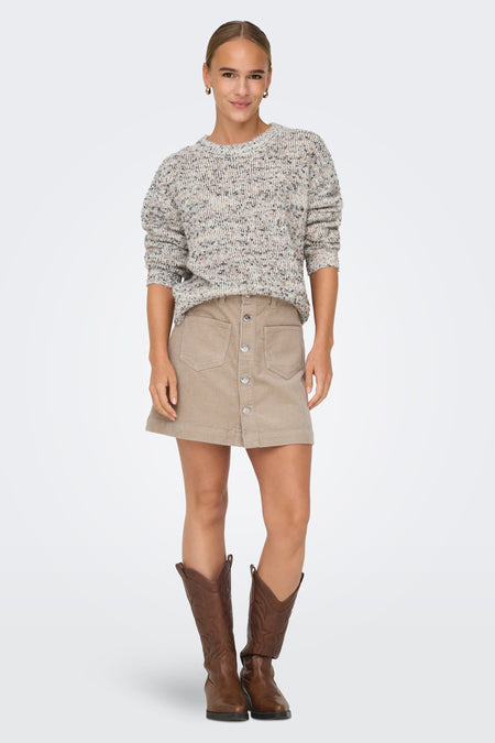 Witte trui met ronde hals van ONLY, met gemêleerd patroon en gedragen met een beige corduroy rok en bruine laarzen.
