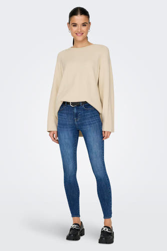 T-shirt écru avec col rond de ONLY, associé à des jeans bleus et des chaussures noires.