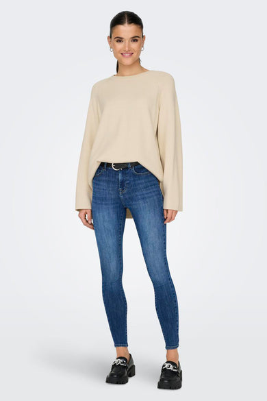 T-shirt écru avec col rond de ONLY, associé à des jeans bleus et des chaussures noires.