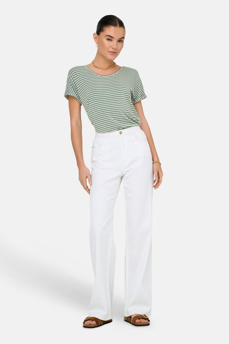 T-shirt vert à manches courtes de JDY, rayé blanc, porté par un mannequin avec un pantalon blanc et des sandales marron.