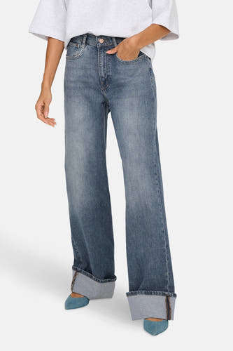 Middenblauwe wijde jeans van ONLY, met omgeslagen pijpen en gecombineerd met blauwe schoenen.
