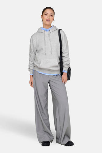 Grijze sweater met kap van ONLY, met trekkoord en gecombineerd met een blouse en pantalon.