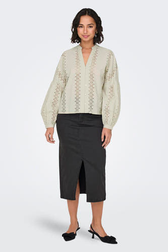 Ecru blouse met lange mouwen van ONLY, met broderie details en gedragen met een zwarte rok met split.
