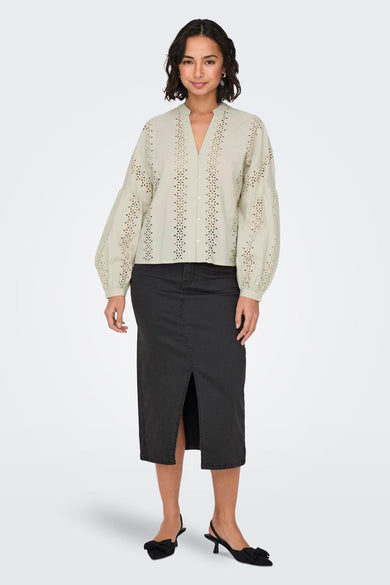 Ecru blouse met lange mouwen van ONLY, met broderie details en gedragen met een zwarte rok met split.
