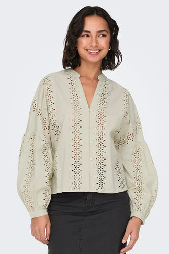 Ecru blouse met lange mouwen van ONLY, met geborduurde details en pofmouwen gecombineerd met een zwarte jeans.
