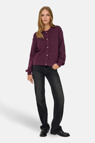 Paarse cardigan van JDY, met lange mouwen en parelmoeren knopen, gecombineerd met een donkere jeans en zwarte loafers.
