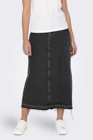 Zwarte lange rok van denim van ONLY met een gerafelde zoom, gecombineerd met een wit shirt en witte sneakers.
