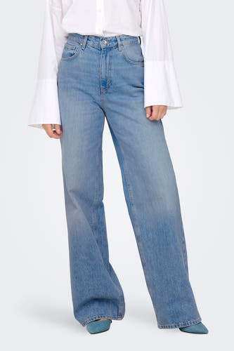 Jean en denim bleu marine ONLY, avec des jambes larges et portés avec une chemise blanche.