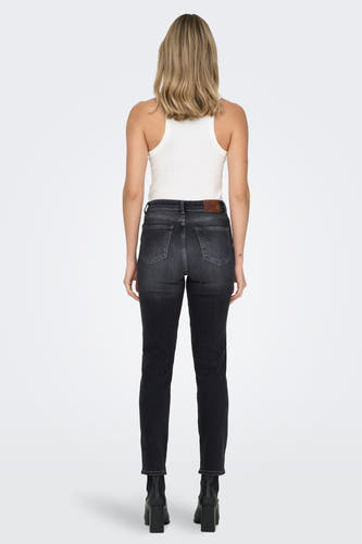 Jean mom noir de ONLY, avec un tank-top blanc et des bottes noires.