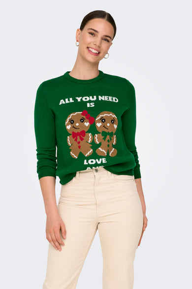 T-shirt vert avec col rond de ONLY, avec une image de Père Noël en gâteau et pantalon beige et chaussures noires.