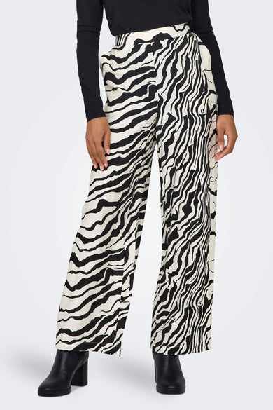 Broek met zebraprint van ONLY, gecombineerd met een zwarte top en zwarte laarzen.
