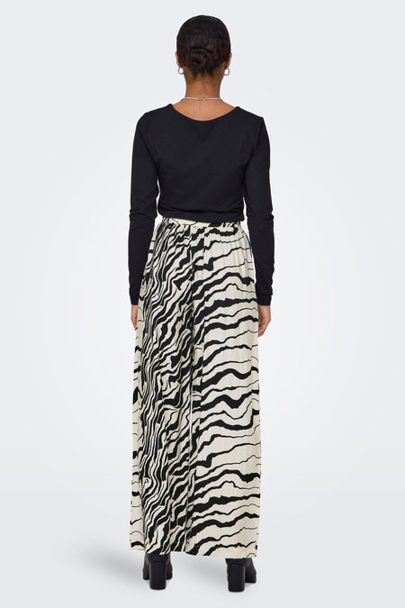 Witte broek van ONLY met zwart zebraprint en een lange wijde pijp, gezien van achteren.
