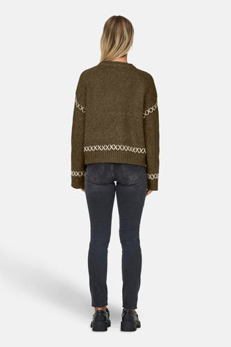 Khaki trui met ronde hals van ONLY®, versierd met witte kruissteek details, gedragen met een zwarte jeans en zwarte schoenen, achteraanzicht.
