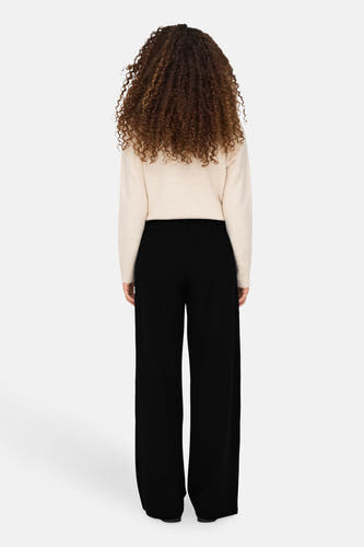 Pantalon noir de JDY, avec des jambes larges et une texture lisse, vu de derrière.