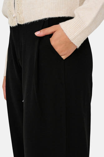 Zwarte broek van JDY, met hand in de zak, en een geplooide voorkant.