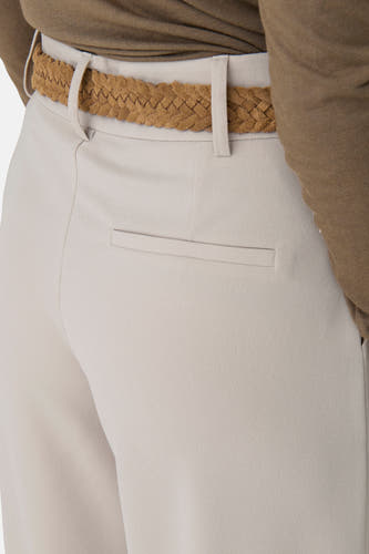Pantalon écru de JDY, avec une ceinture tressée marron et un passant à l'arrière.
