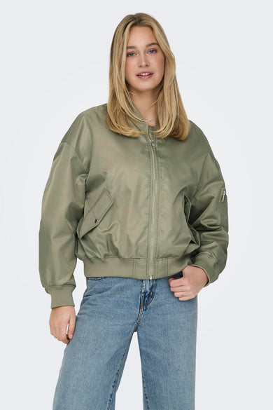 Groene korte jas van ONLY, met rits en zakken, gedragen met een blauwe jeans.
