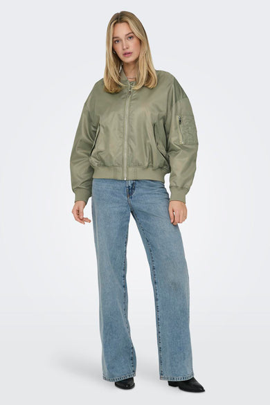 Groene korte jas van ONLY met rits, gecombineerd met wijde jeans en zwarte laarsjes.