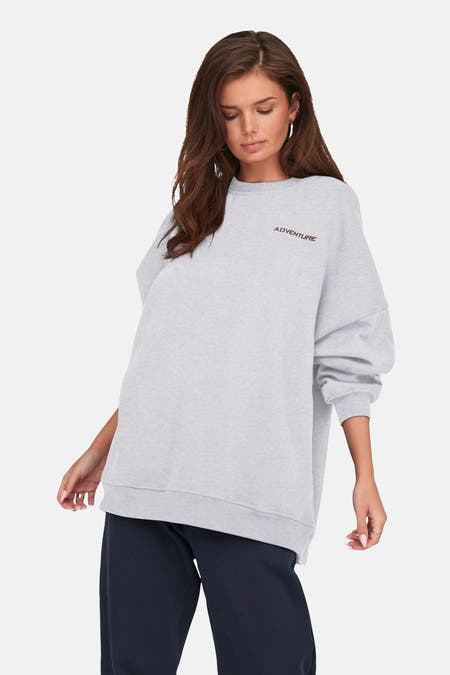 Gilet gris d'ONLY, avec des manches longues et le texte 'Adventure' dessus.